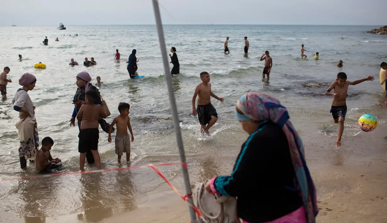 Suasana saat warga Palestina menghabiskan libur Idul Fitri di pantai Tel Aviv, Israel, Sabtu (16/6). (AP Photo/Oded Balilty)