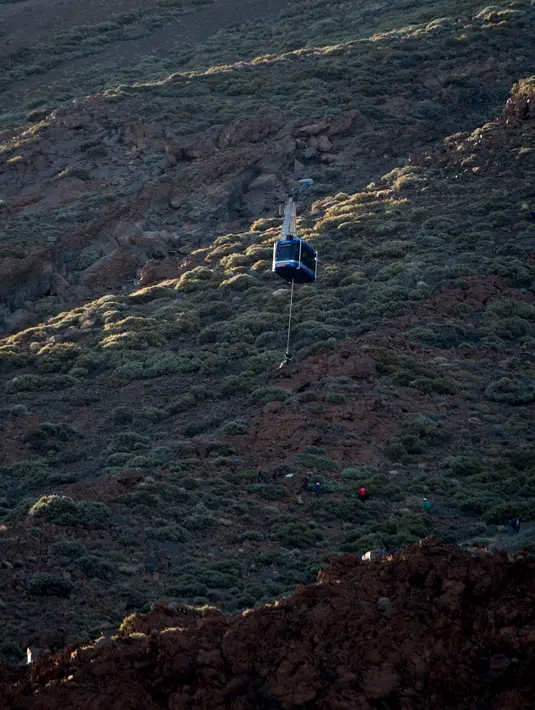 Puluhan wisatawan terperangkap di dua kereta gantung menuju puncak Gunung El Teide (3.718 meter) di Taman Nasional El Teide, Pulau Canary, Spanyol, Rabu (15/3). Belum diketahui penyebab macetnya kabel untuk menarik kereta gantung itu. (Desiree Martin/AFP)