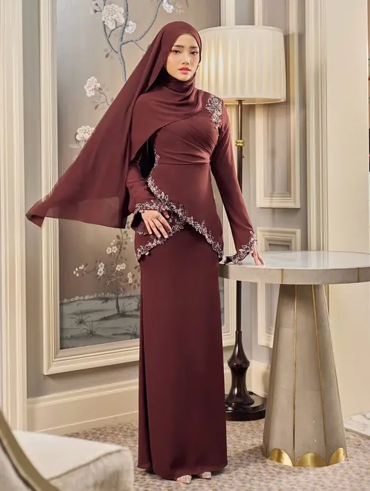 Fuji tampil memukau dalam balutan baju kurung dengan detail slim fit yang mempertegas siluet tubuh dengan anggun. Padukan dengan hijab pashmina warna senada untuk menciptakan tampilan clean dan elegan. [@hijabista.hub].