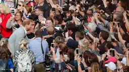 Pangeran Harry menyalami orang-orang di luar Kastil Windsor, Inggris, Jumat (18/5). Pangeran Harry dan Meghan Markle akan menikah pada 19 Mei 2018. (AP Photo / Frank Augstein)
