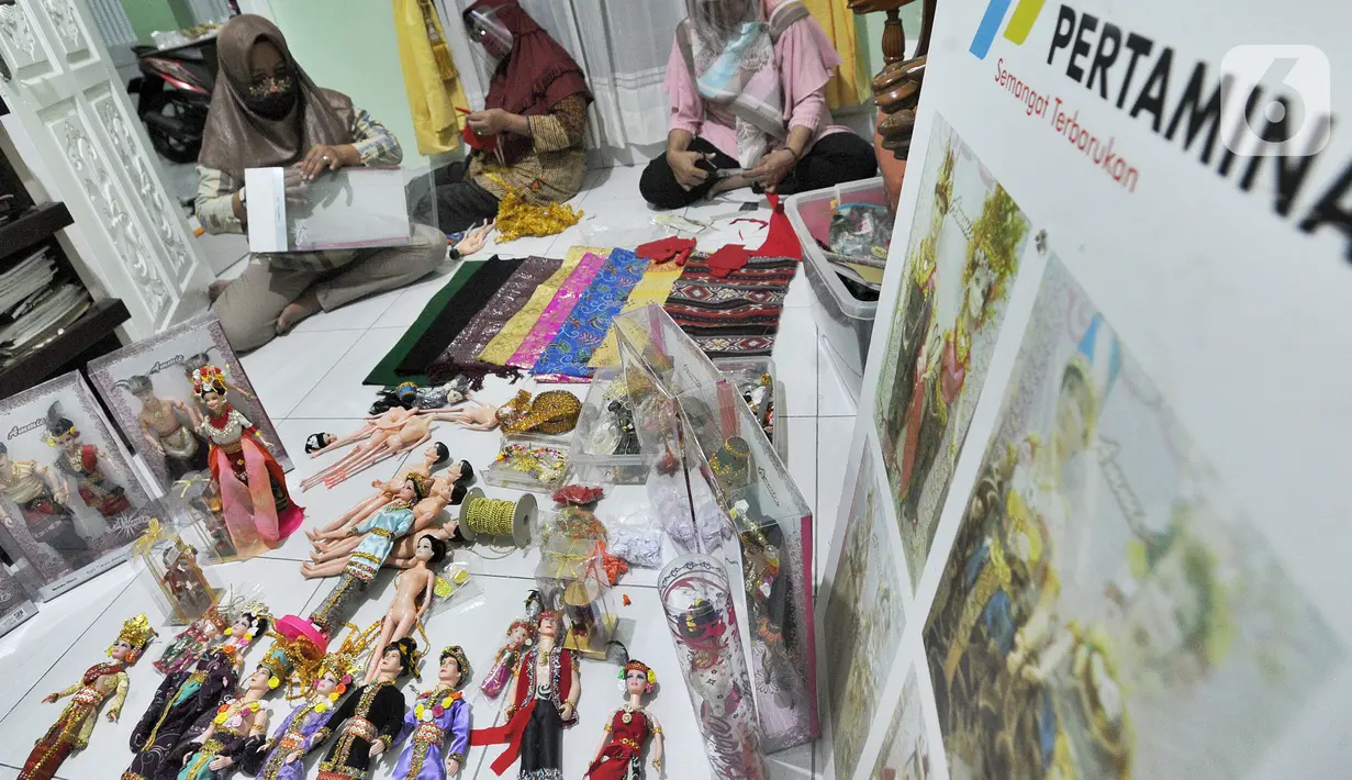 Ibu rumah tangga menyelesaikan pembuatan boneka adat Indonesia di Ammie Dolls di Komplek Pondok Tirta, Depok, Kamis (13/08/2020). Pada masa pandemi ini produksi dan penjualan anjlok hingga 95 persen menyebabkan perajin beralih ke bidang lain untuk mencukupi kebutuhan hidup. (merdeka.com/Arie Basuki)