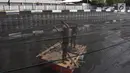 Dua petugas memasang jaring hitam di Kali Item, Kemayoran, Jakarta, Jumat (20/7). Pemasangan jaring dilakukan untuk menutupi keruhnya air dan bau tak sedap di Kali Item. (Liputan6.com/Arya Manggala)