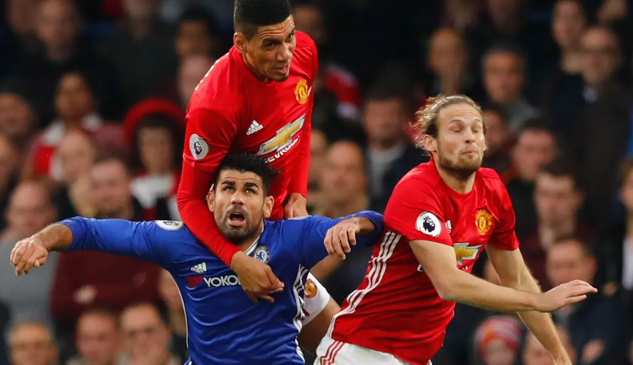 Penyerang Chelsea, Diego Costa berebut bola udara dengan pemain MU, Chris Smalling dan Daley Blind pada Liga Inggris di Stadion Stamford Bridge, London, Inggris (23/10). Chelsea menang atas MU dengan skor akhir 4-0. (Reuters/Eddie Keogh)