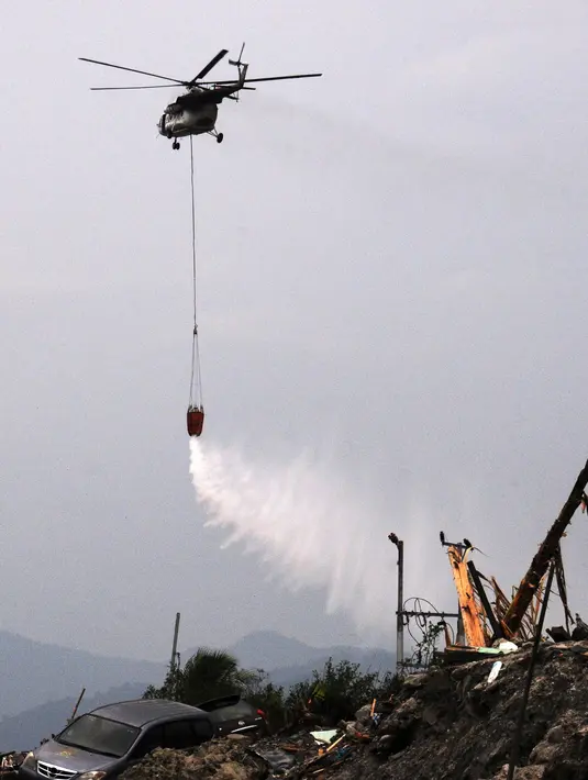 Helikopter BNPB menyemprotkan cairan disinfektan ke kawasan terdampak likuifaksi di Perumnas Petobo dan Balaroa, Palu, Sulawesi Tengah, Kamis (18/10). Penyemprotan dilakukan untuk mengantisipasi penyebaran penyakit. (Muhammad Rifki/AFP)