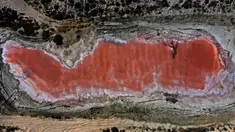 Sebuah gambar yang diambil pada 26 Januari 2021 ini menunjukkan danau merah muda di Ras Al Khaimah di Uni Emirat Arab (UEA). Danau merah muda adalah efek dari ganggang merah menyebabkan perubahan warna air. (GIUSEPPE CACACE/AFP)