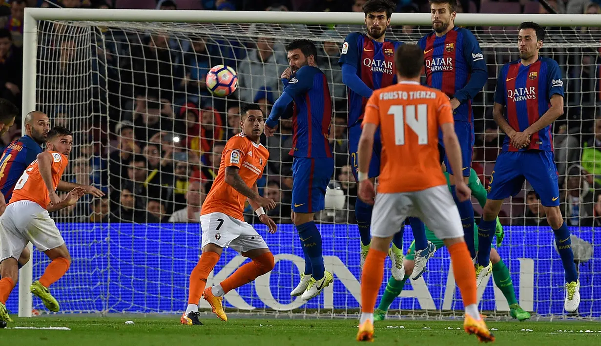 Tendangan bebas dari gelandang Osasuna, Roberto Torres yang akhirnya berhasil membuahkan gol untuk Osasuna saat pertandingan liga Spanyol antara Barcelona vs Osasuna di stadion Camp Nou, Barcelona (26/4). (AFP/Lluis Gene)
