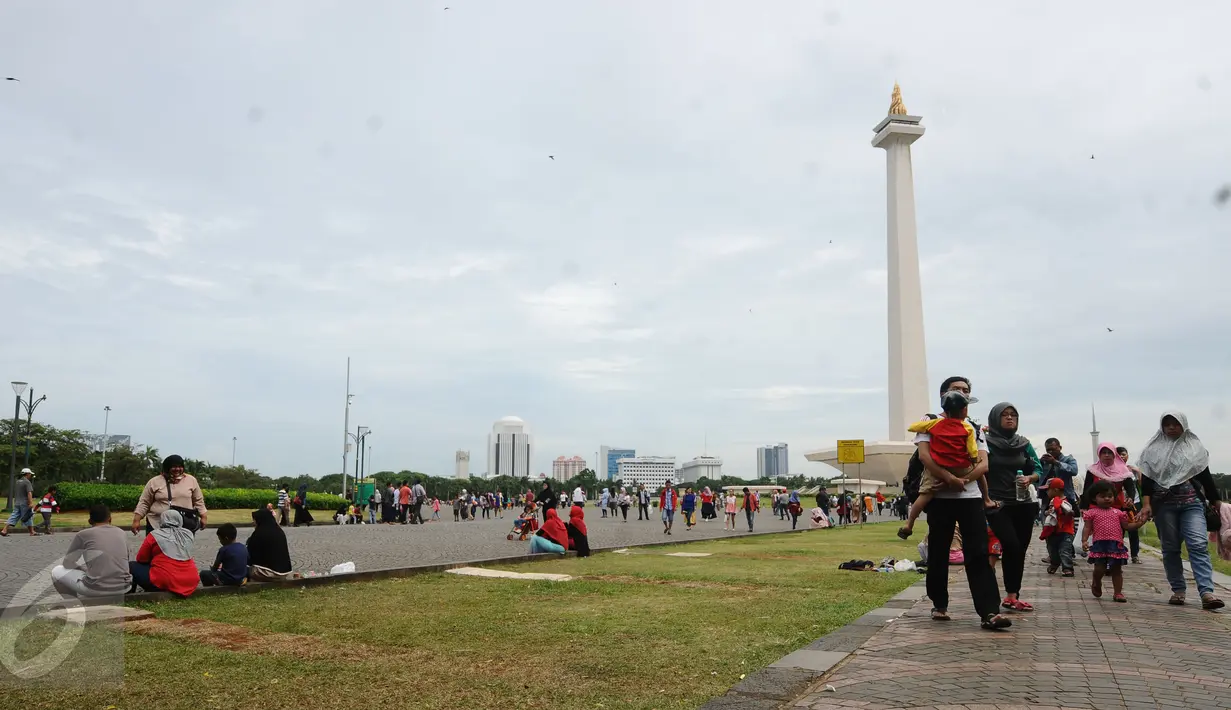 Warga berjalan-jalan di kawasan Monumen Nasional, Jakarta, Minggu (25/12). Libur perayaan Natal 2016 dimanfaatkan sejumlah warga untuk berwisata di kawasan Monumen Nasional. (Liputan6.com/Helmi Fithriansyah)