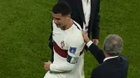 Pemain Timnas Portugal, Cristiano Ronaldo meninggalkan lapangan sambil dihibur pelatih Fernando Santos usai laga babak perempatfinal Piala Dunia 2022 di Al Thumama Stadium, Doha, Qatar, Sabtu (10/12/2022) malam WIB. (AP/Alessandra Tarantino)