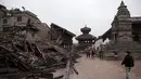 Pejalan kaki melintas di sisi salah satu bangunan bersejarah yang hancur akibat gempa berkekuatan 7,8  di sekitar Kathmandu, Nepal  (30/4/2015). Gempa berkekuatan 7,8 yang meluluhlantakkan Nepal pada 25 April 2015 lalu. (Nicolas Asfouri/AFP)