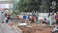 Pekerja menyelesaikan jalur pedestrian di Jalan Sudirman, Jakarta, Senin (2/7). Perbaikan jalur pedestrian di sepanjang koridor Jalan Sudirman menjadi porsi pekerjaan PT MRT Jakarta, ditargetkan selesai pada 31 Juli 2018. (Liputan6.com/Arya Manggala)