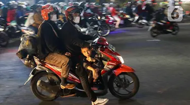 Pemudik yang menggunakan sepeda motor melintas di Jalan Raya Kalimalang, Bekasi, Jawa Barat, Rabu (19/4/2023) malam. (Liputan6.com/Herman Zakharia)