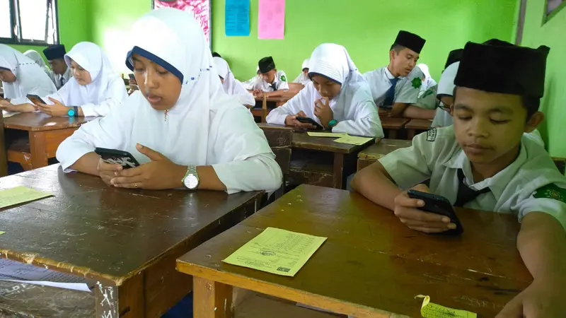 Siswa menggarap soal ujian berbasis android atau  ponsel di MTs Ma’arif NU 2 Cilongok, Banyumas. (Foto: Liputan6.com/Isrodin untuk Muhamad Ridlo)