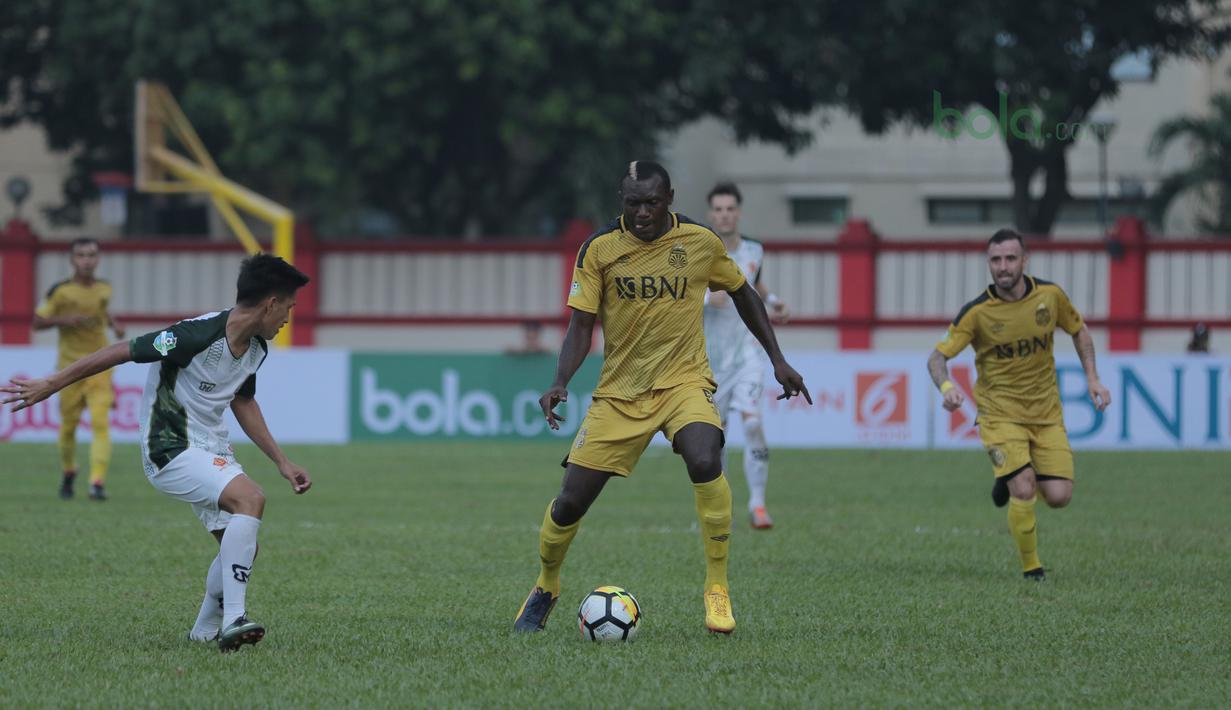 Pemain Bhayangkara FC, Herman Dzumafo (tengah) mencoba melewati pemain PS Tira pada lanjutan Liga 1 2018 di Stadion PTIK, Jakarta, Jumat (4/5/2018). Bhayangkara menang 4-2.  (Bola.com/Nick Hanoatubun)