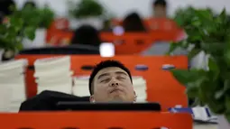 Seorang pegawai terlihat sangat nyenyak ketika tidur siang pada jam istirahat di kantornya, di Beijing, China, (21/4). Kegiatan tidur siang di kantor ini sudah menjadi budaya atau kebiasaan. (REUTERS/Jason Lee)