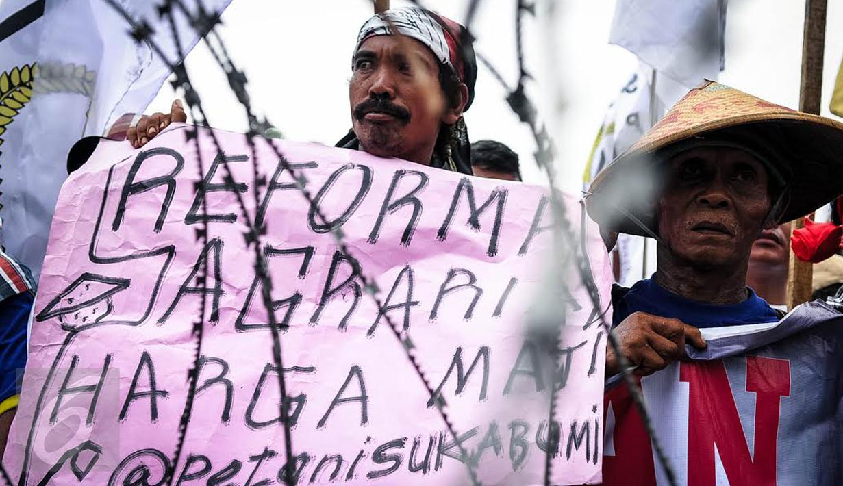 Massa yang mengatasnamakan petani dari berbagai provinsi menbentangkan poster saat menggelar demonstrasi di kawasan Medan Merdeka, Jakarta, Selasa (27/9). Aksi tersebut digelar dalam rangka memperingati Hari Tani Nasional. (Liputan6.com/Faizal Fanani)
