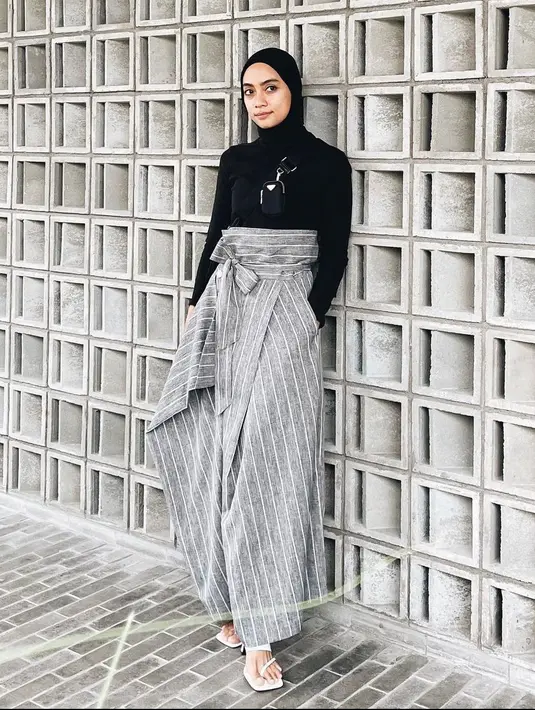 Jika ingin tampil simpel dan elegan maka kaos hitam dan celana ikat berwarna abu-abu dengan motif garis-garis putih adalah pilihan yang tepat. (instagram/ayudiac)