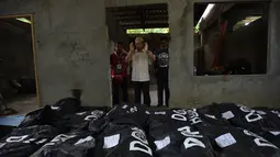 Seorang imam berdoa di depan jenazah korban pengepungan Marawi sebelum dimakamkan di sebuah pemakaman di Iligan City, di pulau selatan Mindanao (24/7). Pemerintah Filipina memperpanjang darurat militer di Marawi hingga akhir tahun. (AFP Photo/Ted Aljibe)
