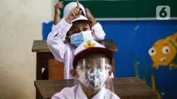 Siswa mengikuti uji coba pembelajaran tatap muka (PTM) perdana di SD Negeri 14 Pondok Labu, Jakarta, Senin (30/8/2021). Pembelajaran tatap muka (PTM) terbatas Tahap 1 di Provinsi DKI Jakarta digelar dengan kapasitas 50 persen pada setiap satuan pendidikan. (Liputan6.com/Faizal Fanani)