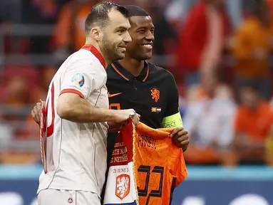 Tindakan elegan dan penuh respek dilakukan oleh Timnas Belanda dengan memberi penghormatan kepada Goran Pandev yang pensiun usai pertandingan tersebut dengan memberinya jersey Belanda dengan nama Pandev. (Foto: AFP/Pool/Koen van Weel)