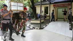 Petugas mengangkat 13 peti ke ruang transit jenazah yang dipersiapkan untuk korban helikopter TNI yang jatuh di RS Polri, Jakarta, Senin (21/3). Helikopter TNI AD jenis Bell 412 EP jatuh pada Minggu 20 Maret kemarin. (Liputan6.com/Yoppy Renato)