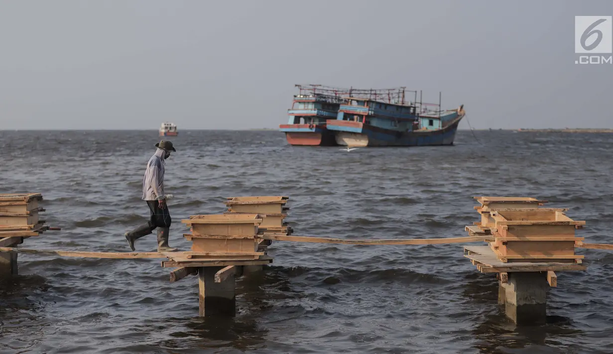 Pekerja menyelesaikan pondasi dermaga di Muara Angke, Jakarta Utara, Rabu (3/7/2019). Pemprov DKI Jakarta membangun dermaga dengan panjang mencapai 300 meter dengan lebar sekitar tujuh meter dilengkapi dengan jembatan penghubung serta pemecah ombak sepanjang 480 meter. (Liputan6.com/Faizal Fanani)