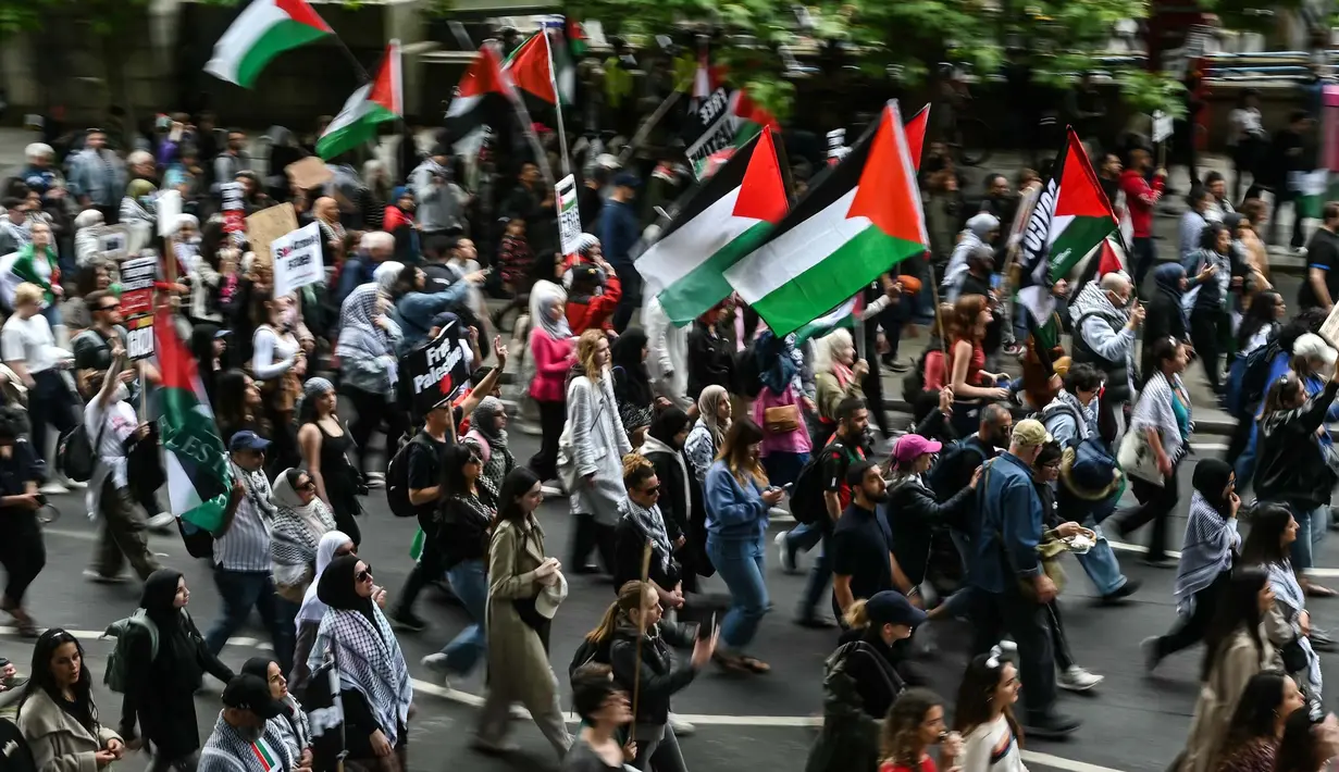 Para pengunjuk rasa memegang plakat dan mengibarkan bendera Palestina saat mereka mengambil bagian dalam “Pawai Nasional untuk Gaza”, di pusat kota London, pada 8 Juni 2024. (JUSTIN TALLIS/AFP)