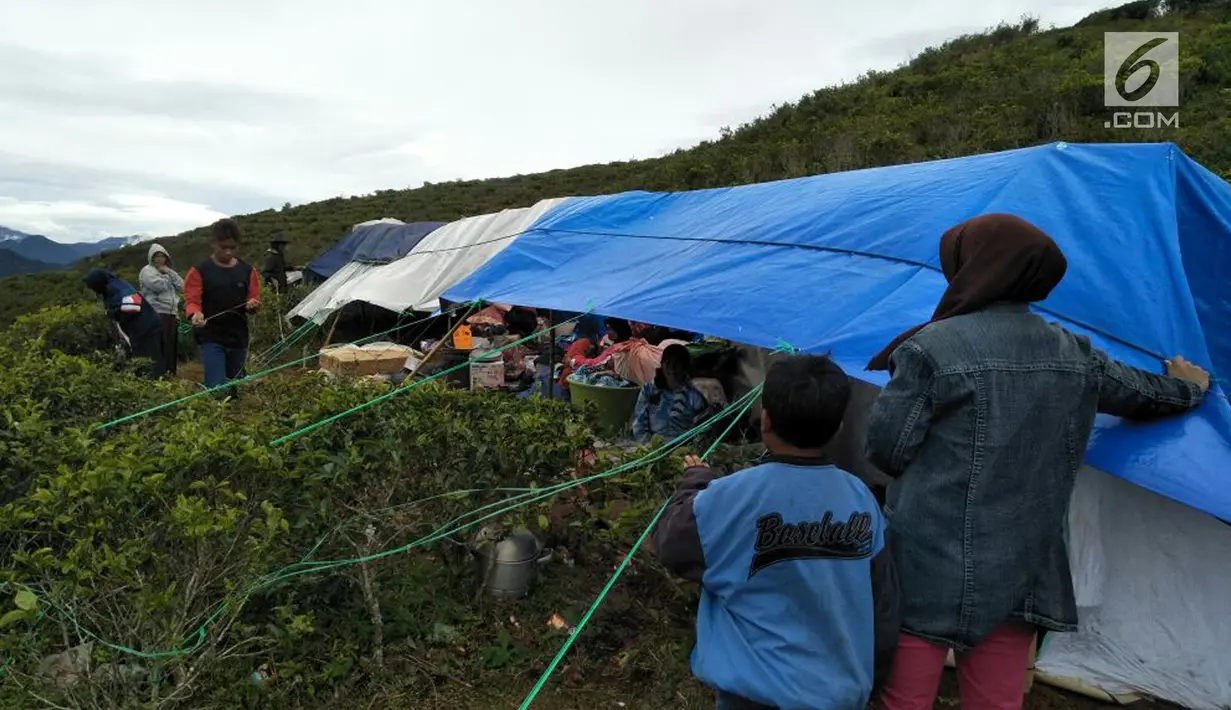 Warga berteduh dalam tenda di perkebunan teh milik PT Nirmala di Desa Malasari, Kecamatan Nanggung, Kabupaten Bogor, Jawa Barat. Warga khawatir akibat gempa dan hujan menimbulkan tanah longsor di desanya. (Liputan6.com/Achmad Sudarno)