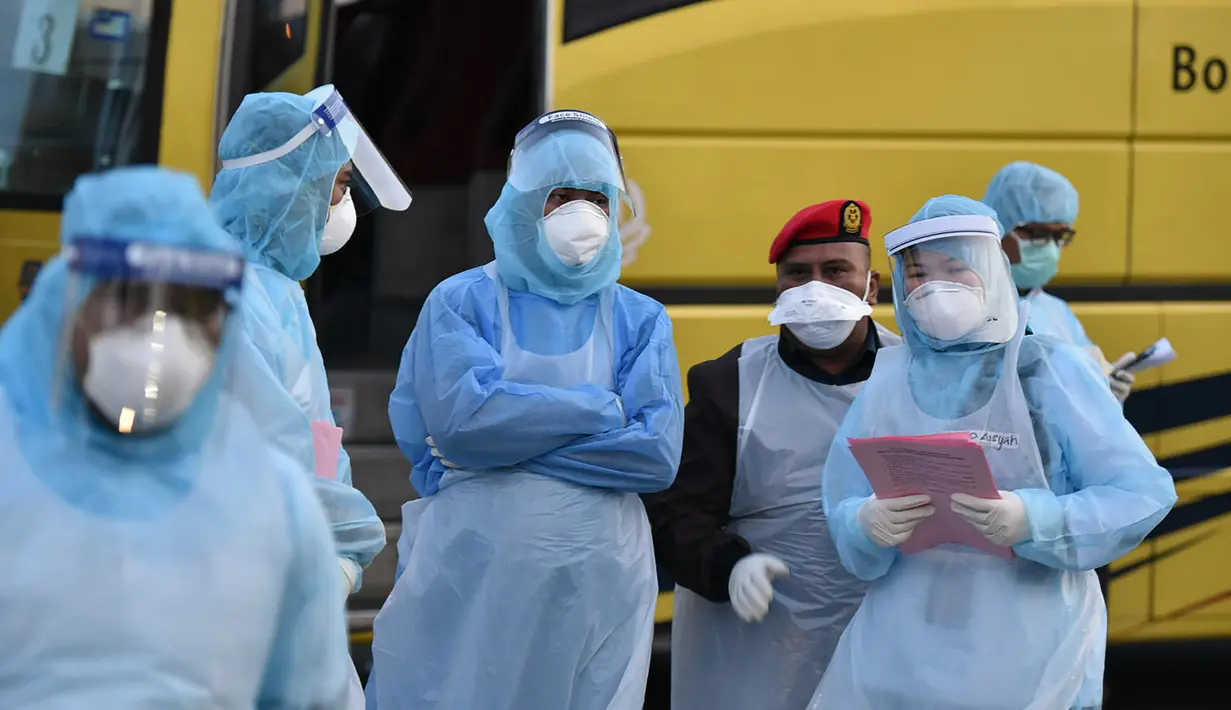 Petugas berbincang saat warga Malaysi tiba setelah dievakuasi dari Wuhan, China akibat virus corona di Bandara Internasional Kuala Lumpur di Sepang, Selasa, (4/2/2020). Sejumlah 107 warga Malaysia dievakuasi Wuhan, China. (Muzzafar Kasim/Malaysia's Ministry of Health/AFP)