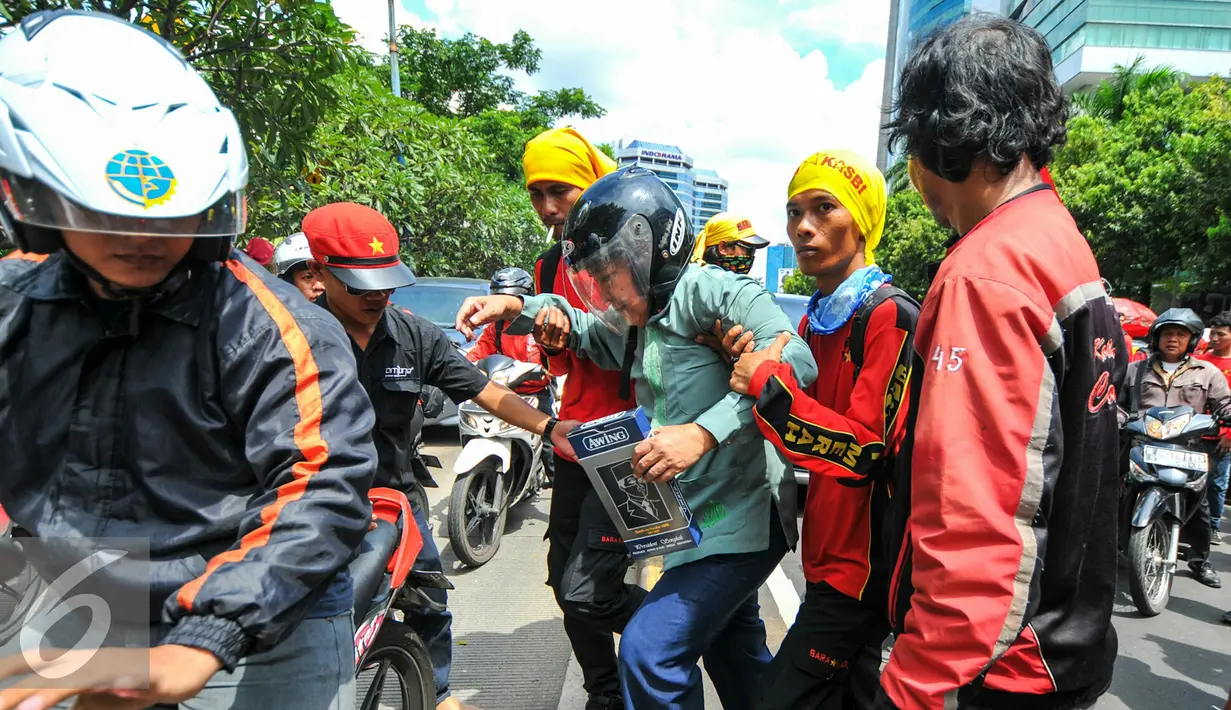 Pendemo membantu pengendara motor untuk masuk ke jalur Transjakarta, Jakarta, Rabu (4/5). Ribuan bidan desa menggelar aksi demo dan menutup akses jalur lambat di depan kantor Kemenkes menyebabkan kemacetan panjang. (Liputan6.com/Yoppy Renato)