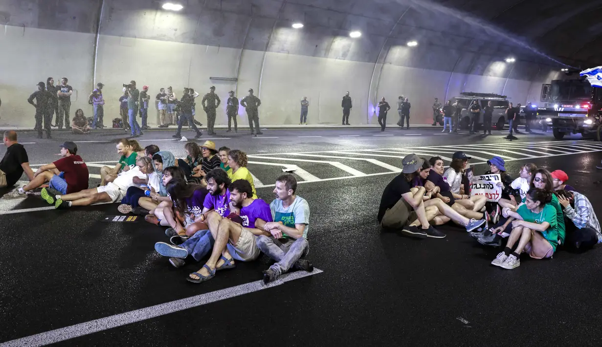 Untuk membubarkan massa, polisi terpaksa menembakkan air ke arah pengunjuk rasa. (Menahem Kahana/AFP)