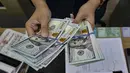 Seorang menghitung uang kertas Dolar AS di salah satu kantor penukaran uang, Jakarta, Selasa 12 Mei 2026. Nilai tukar rupiah terhadap dolar Amerika Serikat (USD) terpuruk pada perdagangan Selasa (12/5/2026). (BAY ISMOYO/AFP)