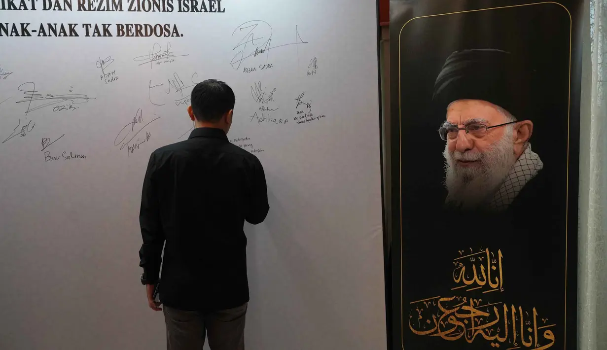 Dalam kegiatan tersebut, warga yang hadir turut menandatangani petisi sebagai bentuk solidaritas dan kepedulian terhadap para korban, termasuk pejabat dan masyarakat sipil Iran yang terdampak situasi konflik. Tampak dalam foto, seorang pria menandatangani dinding penghormatan sementara untuk mendiang Pemimpin Tertinggi Iran Ayatollah Ali Khamenei di kediaman duta besar Iran untuk Indonesia, Jakarta, Kamis 5 Maret 2026. (AP Photo/Tatan Syuflana)