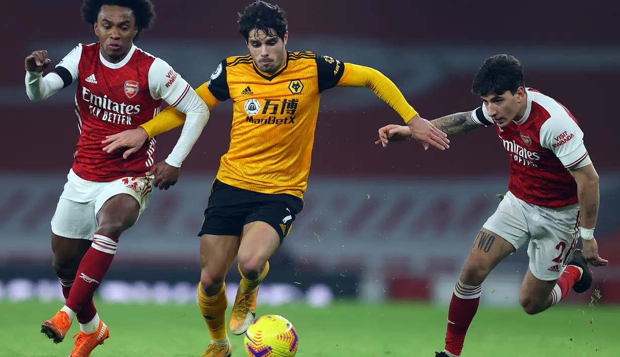 Pemain Arsenal, Willian (kiri) dan Hector Bellerin (kanan) berusaha merebut bola dari gelandang Wolverhampton Wanderers Pedro Neto pada pekan kesepuluh Liga Inggris di Emirates Stadium, London, Minggu (29/11/2020). Arsenal takluk 1-2 dari Wolverhampton Wanderers. (JULIAN FINNEY/POOL/AFP)