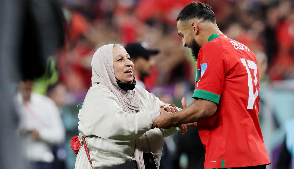 Pemain Maroko, Sofiane Boufal, merayakan kemenangan atas Portugal bersama ibunya pada laga perempat final di Stadion Al-Thumama, Sabtu (10/12/2022). (AFP/Karim Jaafar)