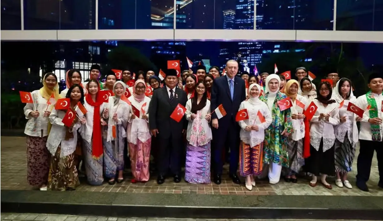 Emine memilih tampil dengan outer panjang loose warna hijau, dipadukan kerudung, dan inner warna begitu. Begitu pun dengan warna celananya. [@prabowo]