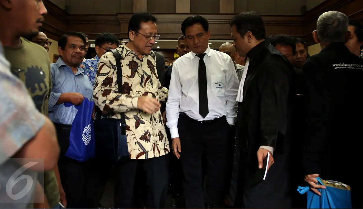 Terdakwa kasus dugaan suap gula impor yang juga mantan Ketua DPD, Irman Gusman bersama pengacaranya, Yusril Ihza Mahendra berbincang sambil berjalan keluar ruang sidang Pengadilan Tipikor Jakarta, Selasa (15/11). (Liputan6.com/Johan Tallo)