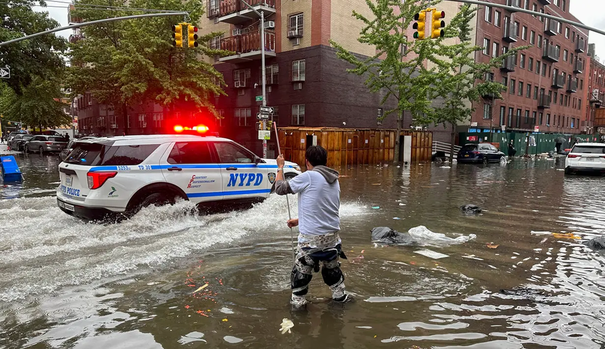 Seorang pria bekerja membersihkan saluran air akibat banjir di wilayah Brooklyn, New York, Amerika Serikat, Jumat (29/9/2023). Hujan badai yang dahsyat pada jam-jam sibuk telah melanda wilayah metropolitan New York. (AP Photo/Jake Offenhartz)