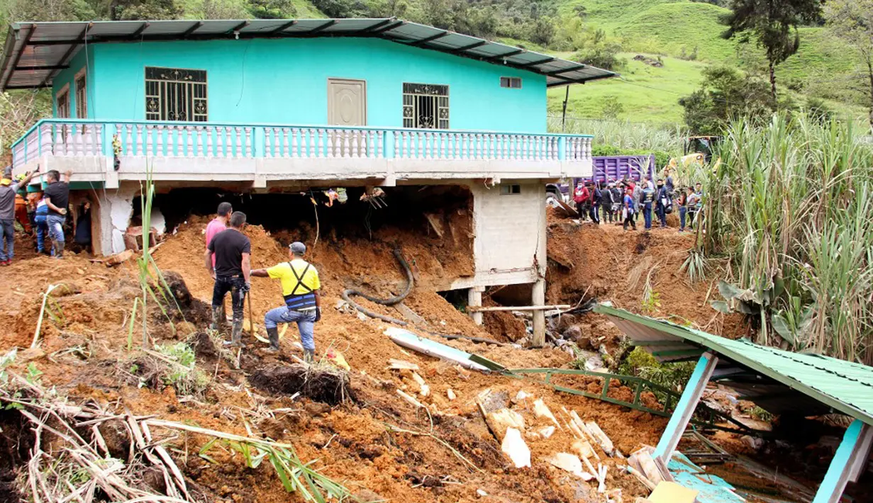 Warga mencari korban selamat setelah tanah longsor mengubur dua rumah di Mallama, Provinsi Narino, Kolombia, 2 November 2021. Sebanyak empat orang tewas dan beberapa dikhawatirkan terjebak menyusul longsor akibat hujan deras di daerah tersebut. (LEONARDO CASTRO/AFP)