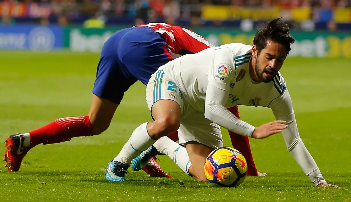 Pemain Real Madrid, Isco dan pemain Atletico Madrid, Lucas terjatuh saat pertandingan pekan ke-12 Divisi Primera La Liga Spanyol di Stadion Wanda Metropolitano, Sabtu (18/11). Laga Derbi Madrid itu berakhir imbang tanpa gol. (AP/Paul White)