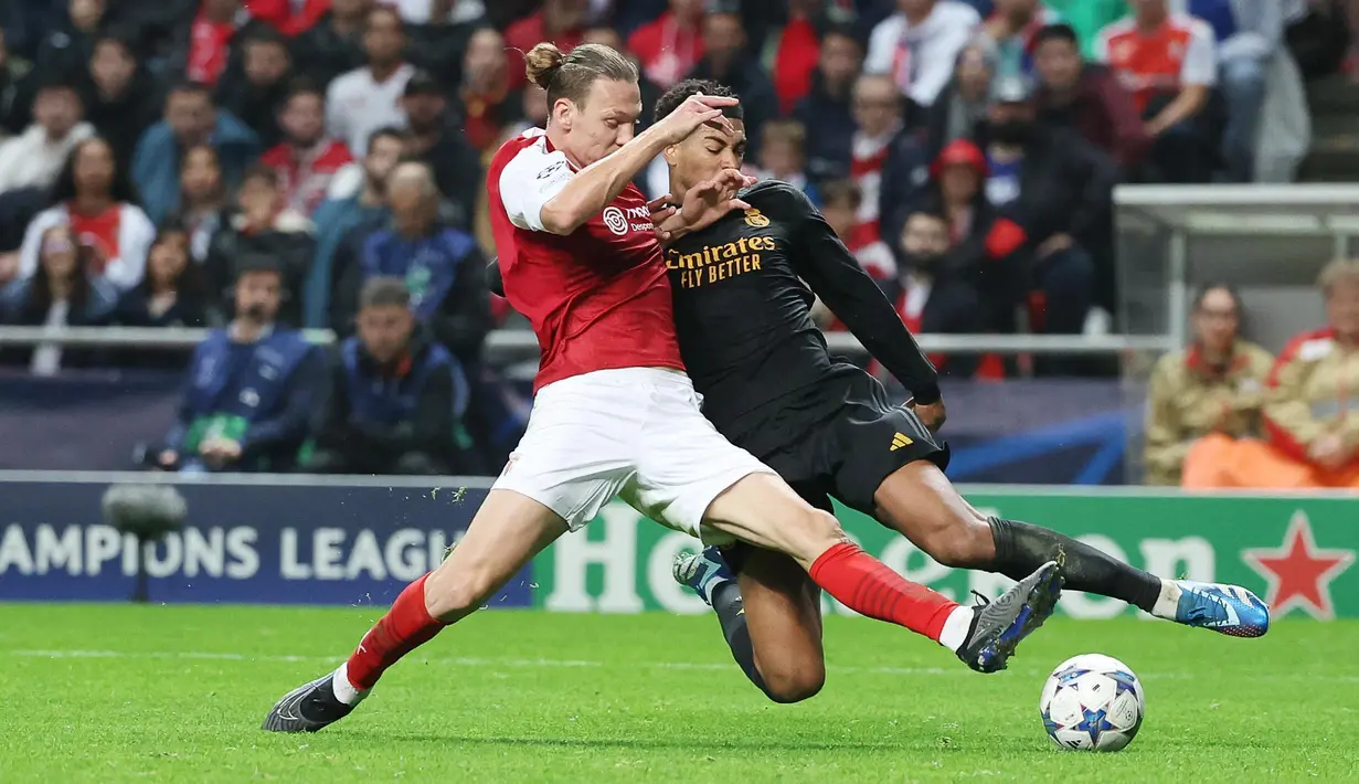 Pamain Real Madrid, Jude Bellingham, berebut bola dengan pemain Braga, Serdar Saatci, pada matchday 3 Liga Champions 2023/2024 di Stadion Municipal, Rabu (25/10/2023). (AFP/Pierre-Philippe Marcou)