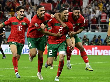 Maroko berhasil mencetak sejarah baru dengan finis di peringkat keempat Piala Dunia 2022. Skuad berjuluk Singa Atlas tersebut secara mengejutkan mampu menaklukkan negara-negara unggulan Eropa seperti Belgia, Spanyol, dan Portugal. Atas penampilan gemilang anak asuh Walid Regragui, Maroko berhasil menjadi tim dengan kenaikan peringkat FIFA paling tinggi. Hakimi dan kolega yang awalnya menduduki peringkat ke-22 naik sebelas tingkat menjadi peringkat ke-11. (AFP/Javier Soriano)