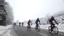Deretan pebalap beraksi di bawah hujan salju dalam Etape 3 balap sepeda Paris-Nice antara Cusset dan Mont Brouilly, Prancis, (9/3/2016). (AFP/Kenzo Tribouillard)