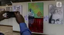 Pengunjung melihat karya lukis dan karya foto pada pameran 150 Tahun Mahatma Gandhi di kompleks Parlemen, Senayan, Jakarta, Jumat (2/10/2020). Pameran ini kerjasama Kedubes India dan DPR mengambil tema "kebenaran, anti kekerasan dan Satyagraha". (Liputan6.com/Johan Tallo)