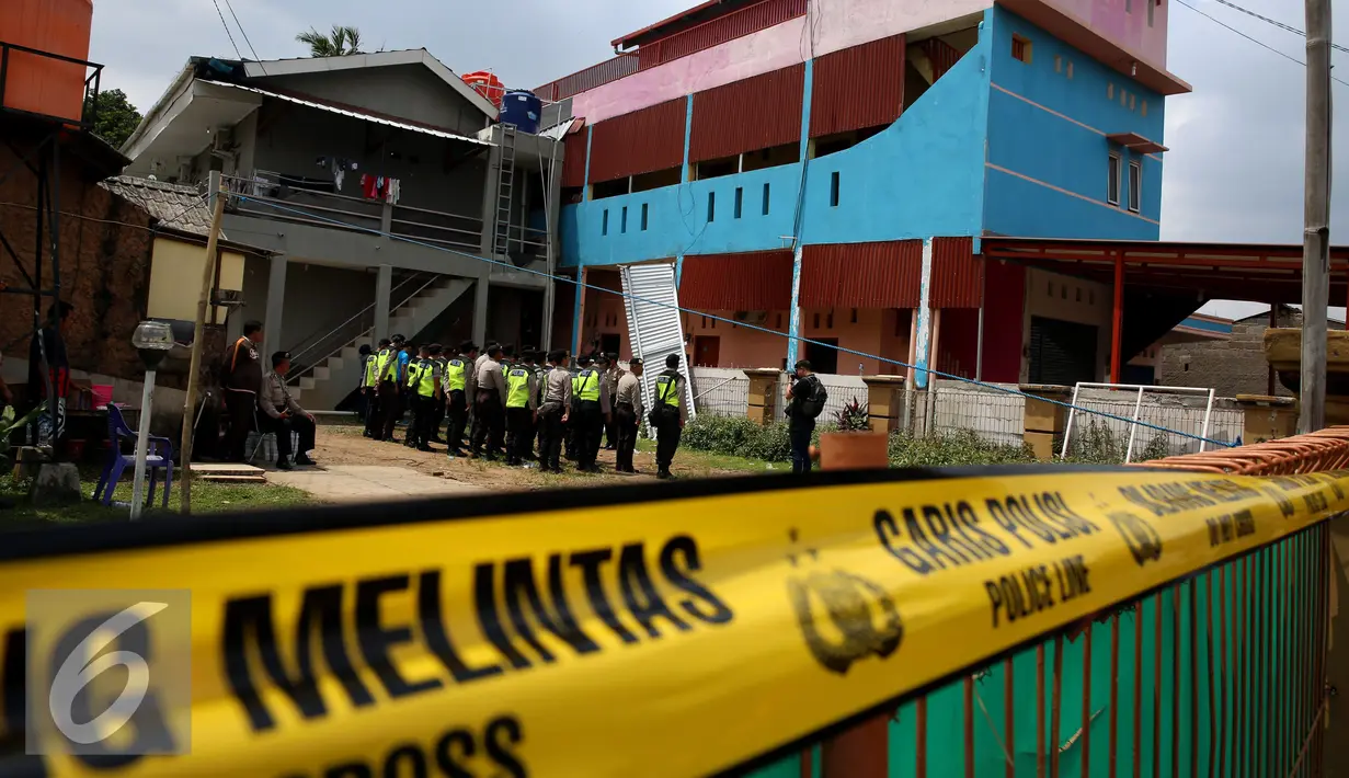 Petugas Kepolisian berjaga di rumah terduga anggota jaringan teroris, Bekasi, Minggu (11/12). Densus 88 menangkap tiga orang terduga anggota kelompok teroris dan menemukan bom siap ledak. (Liputan6.com/Johan Tallo)
