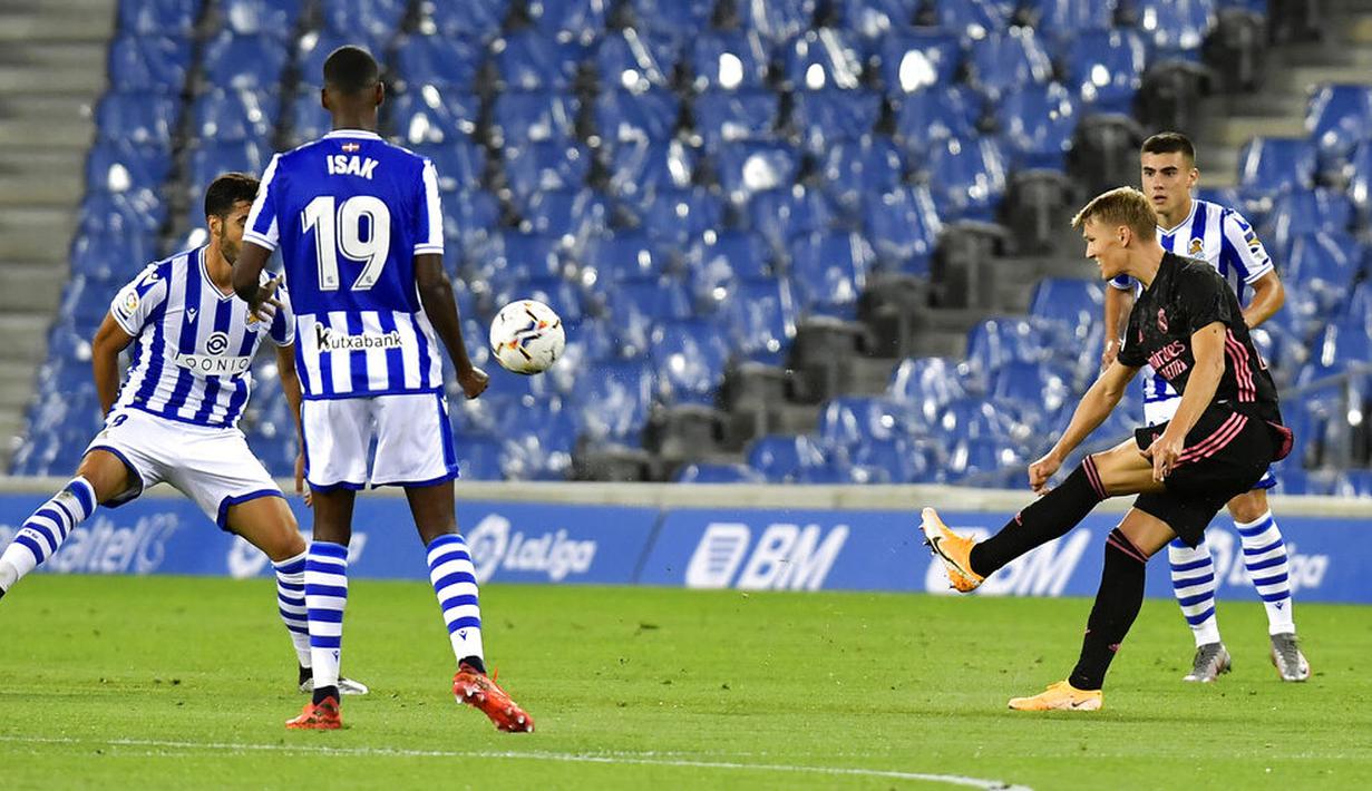 Pemain Real Madrid, Martin Odegaard, melepaskan tendangan saat melawan Real Sociedad pada laga Liga Spanyol di Stadion Anoeta, Minggu (20/9/2020). Kedua tim bermain imbang 0-0. (AP/Alvaro Barrientos)