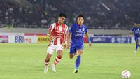 Penyerang Persis Solo, Ramadhan Sananta, saat tengah berebut bola dengan bek PSIS Semarang, Wahyu Prasetyo, pada laga bertajuk Derby Jawa Tengah di Stadion Manahan, Solo, Sabtu (16/9/2023). (Bola.com/Radifa Arsa)