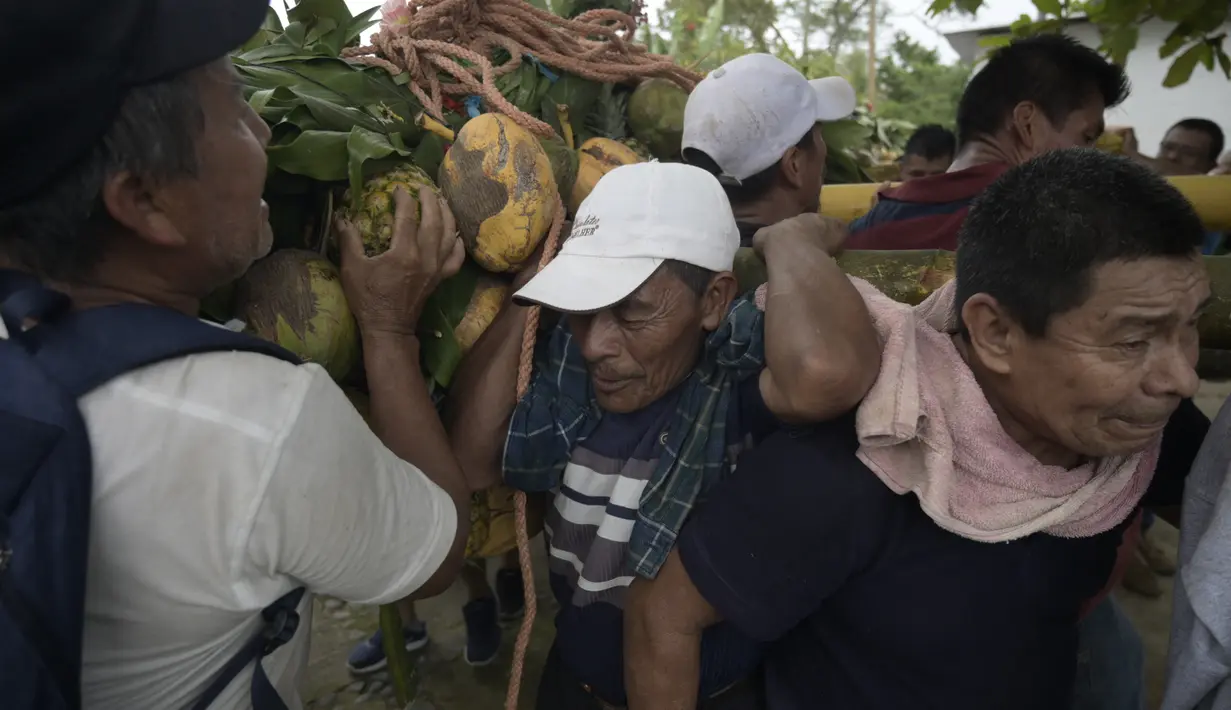 Laki-laki membawa seikat buah di tiang bahu selama perayaan Santa Cruz di Santa Maria Ostuma, 65 km timur San Salvador (31/5/2022). Ratusan orang Salvador membawa buah dengan yodes kayu berjalan melalui desa Santa Maria Ostuma di El Salvador tengah untuk berterima kasih kepada Salib Suci atas panen yang melimpah. (AFP/MARVIN RECINOS)