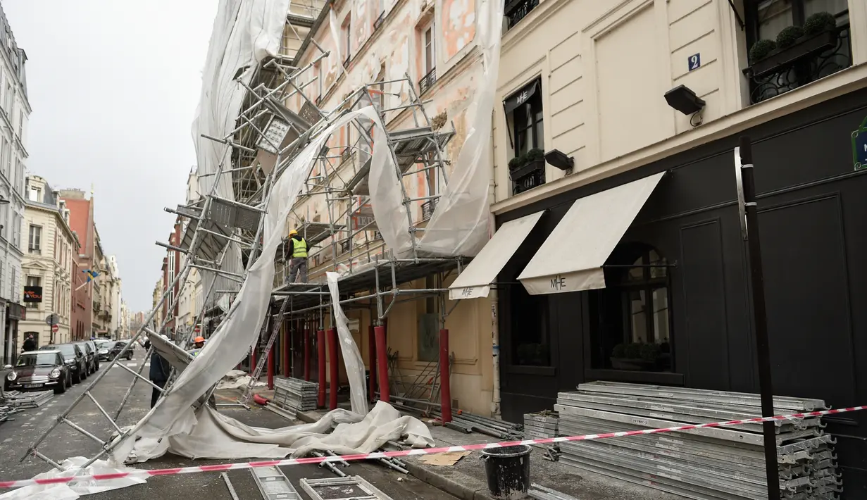 Pekerja melihat kerusakan yang terjadi usai penyangga proyek bangunan ambruk terkena angin kencang di Paris, Prancis (3/1). Tiang penyangga ini berjatuhan akibat terkena angin kencang dari badai Eleanor. (AFP Photo/Stephane De Sakutin)