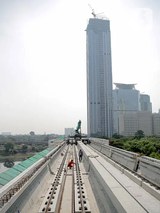Pekerja mengecek perlintasan LRT di jembatan bentang panjang Dukuh Atas, Jakarta, Rabu (11/11/2020). Jembatan bentang panjang hari ini melakukan pengecoran terakhir panjangnya 128 meter. pekerjaan ini menandai selesainya pengerjaan lintasan atas LRT Jabodebek tahap I. (Liputan6.com/Faizal Fanani)