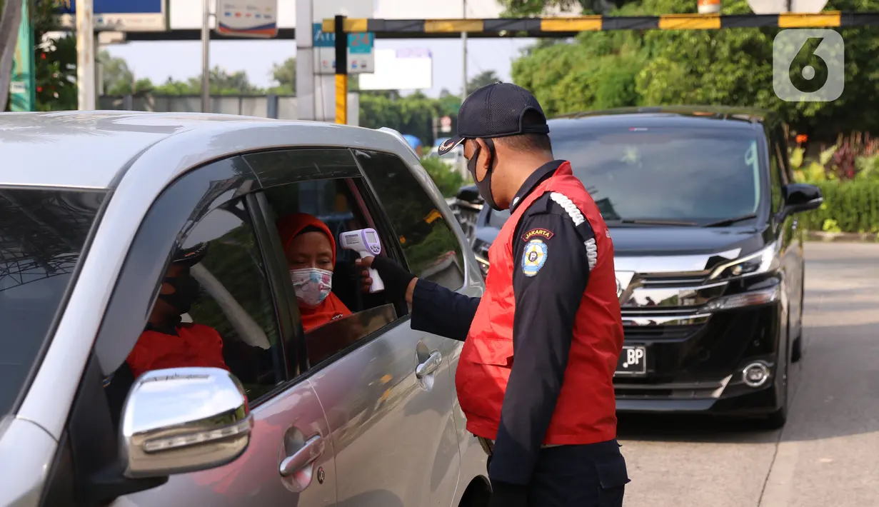 Petugas mengecek suhu tubuh penumpang di Rest Area KM 13,5 Palm Square Tol Jakarta-Tangerang, Jumat (29/5/2020). Penerepan parkir berjarak dan pengecekan suhu tubuh di area tersebut diberlakukan untuk menekan penyebaran Covid-19. (Liputan6.com/Angga Yuniar)